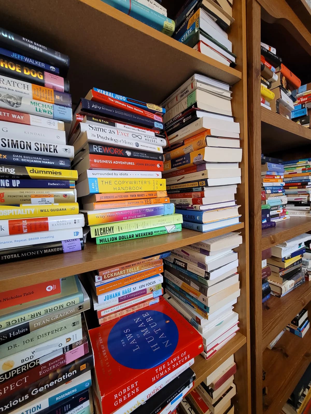 Wooden bookshelves in the BrainToon office filled with paper books on business, psychology, and personal development